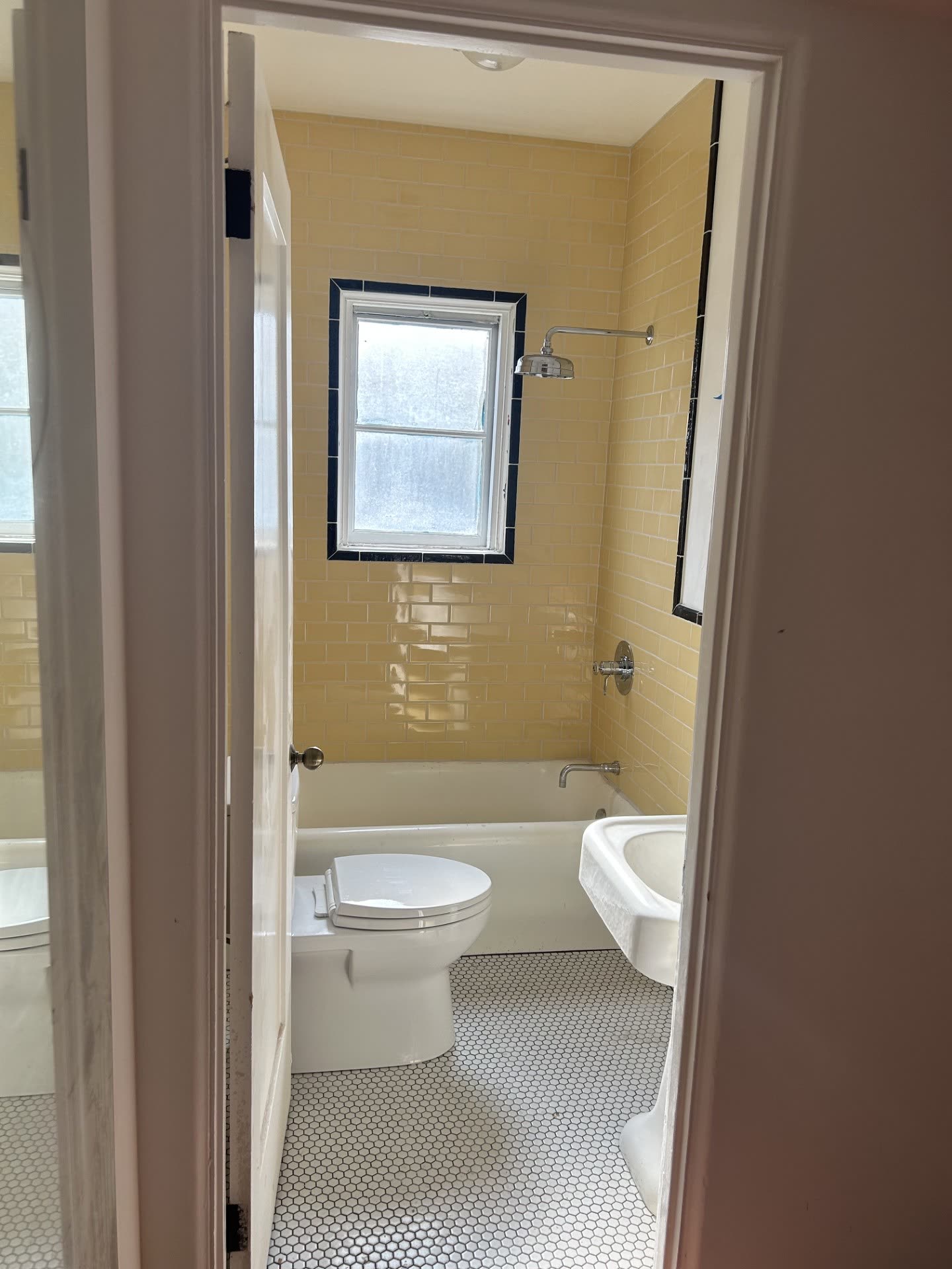 Restored guest bathroom with original yellow subway tile